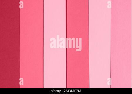 background and backdrop of sheets of paper red pink purple hue colors arranged in a row. mockup and space for text. toned in viva magenta, trend color Stock Photo