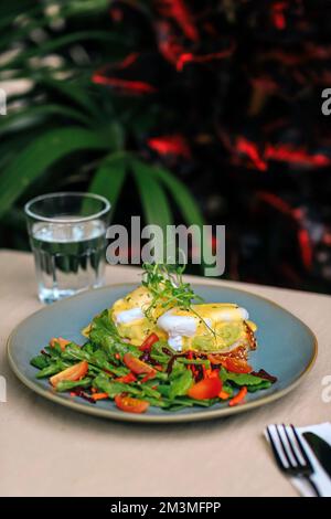 Vegetarian egg Benedict and fresh salad on the plate Stock Photo