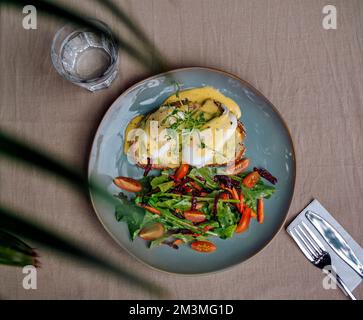 Vegetarian egg Benedict and fresh salad on the plate Stock Photo