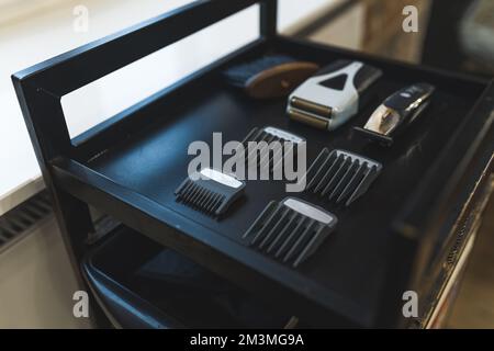 Electric shaving trimmer kit. Shaving equipment. Barber tools. Black barber trolley. Extreme close-up shot. Stock Photo