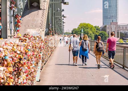 30 July 2022, Cologne, Germany: People walking by the Koln bridge over Rhine river Stock Photo