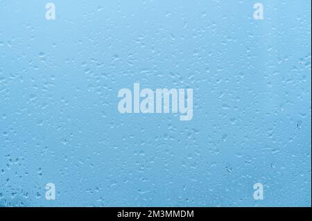 Water Drops Background. Rain drops on window on blue sky, blue background. drop of water on glass . blue background drops glass abstract texture Stock Photo