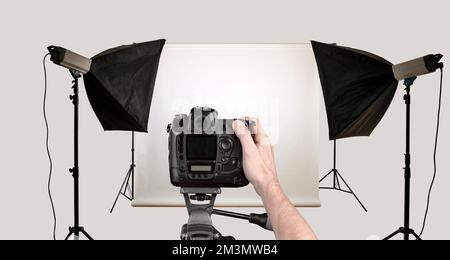 Male hand shoot with black camera in photo studio. Isolated with clipping path Stock Photo