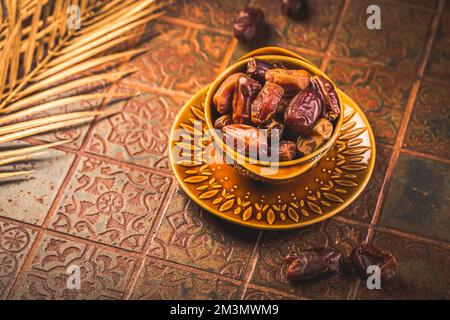 Dried  organic dates in bowl on old kitchen table Stock Photo