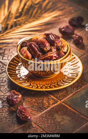 Dried  organic dates in bowl on old kitchen table Stock Photo
