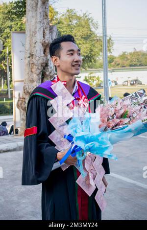 The graduate wore a gown from a university in Thailand. For graduation Stock Photo