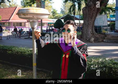 The graduate wore a gown from a university in Thailand. For graduation Stock Photo