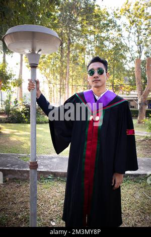 The graduate wore a gown from a university in Thailand. For graduation Stock Photo