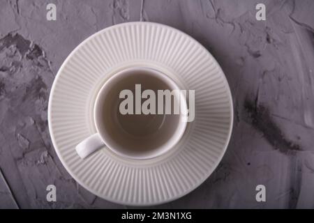 photo empty white cup with saucer top view on a gray irregular background Stock Photo