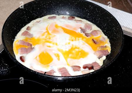 photo of eggs with bacon bits lying on the pan Stock Photo