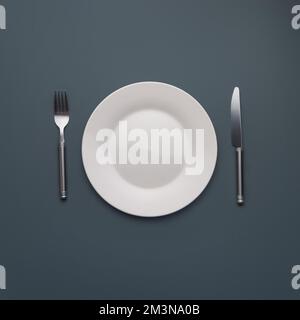 white empty plate with cutlery on dark gray background Stock Photo
