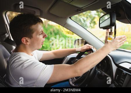 Novice driver sitting in his car behind the wheel shaking threatens another motorist. Bad and aggressive behavior on road concept. Stock Photo