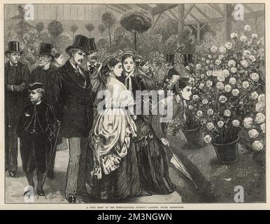 Smartly dressed ladies and gentlemen stroll around a marquee  at a rose show held in the gardens of the Royal Horticultural Society's gardens in South Kensington, London.      Date: 1873 Stock Photo