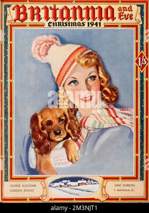 Front cover of Britannia and Eve magazine, Christmas number, featuring a glamorous blonde woman carrying off a woolly scarf and bobble hat with aplomb, while carrying her rather grumpy looking spaniel dog.     Date: 1941 Stock Photo