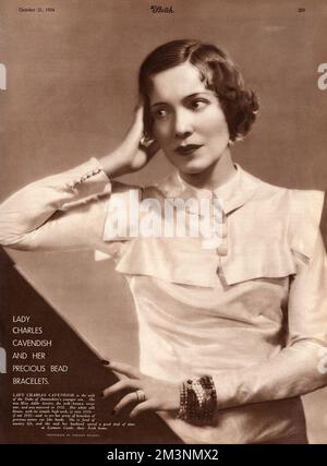 Adele Astaire (1896 - 1981) comedy actress and dance partner of her brother, Fred Astaire from childhood until 1932, when she retired from dance to marry the British aristocrat Lord Charles Spencer Cavendish, second son of the 9th Duke of Devonshire. Pictured here wearing a white silk blouse with a simple high neck described by The Sketch as 'very 1934 - if not 1935, as are her array of bracelets of precious stones cut like beads'.       Date: 1934 Stock Photo