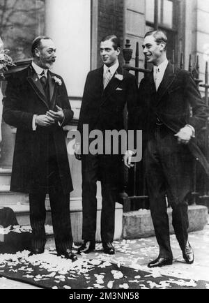 Informal photograph of King George V pictured with two of his sons, Prince George (centre), later Duke of Kent and Prince Albert, later King George VI, all at the wedding of Princess Maud of Fife, the King's niece.  The royal party had just seen the newlyweds (she married Charles Carnegie, Earl of Southesk on November 12th 1923 at the Guards Chapel) hence the confetti of petals lying on the ground.       Date: 1923 Stock Photo