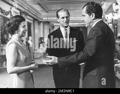 United States President Richard Nixon chats with Queen Elizabeth II and Prince Philip, Duke of Edinburgh when he lunched with the Royal Family at Buckingham Palace on 25th February 1969.       Date: 1969 Stock Photo