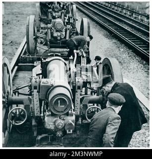 Station porters at a small country station at an undisclosed location in Britain, unloading heavy calibre howitzers from railway trucks.       Date: 1939 Stock Photo