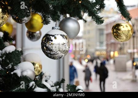 New Year celebration in city, Christmas balls on fir branches. Festive decorations on the street on people background, festivities, winter holiday Stock Photo