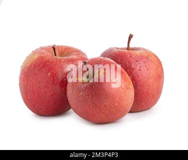 Three red fuji apples in water drops on a white isolated background Stock Photo