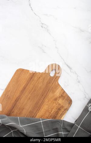 culinary background with wooden cutting board and towel on granite table Stock Photo