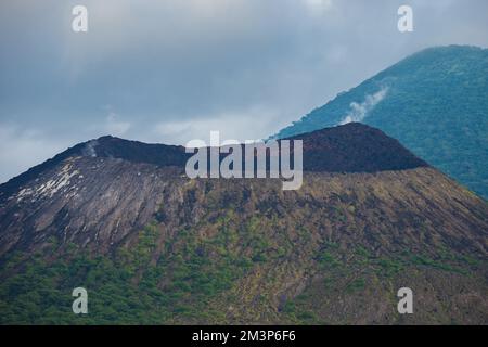 Clouds forming above volcano in the south Pacific Ocean - Ring of fire Volcano in Papua Stock Photo