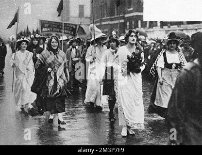 The women's right-to-serve procession as it passed through Westminster, London. The demonstration, which took place on July 17th 1915, was organised to demand the right for women to be allowed to share in munition and other war work.Ireland, Scotland, England and Wales are depicted here by four women as part of the procession.     Date: 17th July 1915 Stock Photo