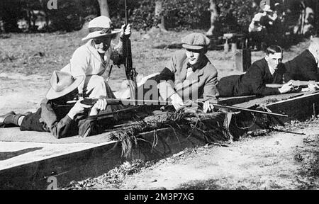 Mrs Baliol Scott, the famous woman rifle shot, teaching  boys how to shoot at the Byfleet Ladies' Rifle Range of which she was a prominent member.  The club gave instruction and free ammunition to all men who cared to attend and the picture here shows a boy scout taking aim at a target under Mrs Scott's watchful eye.       Date: 1914 Stock Photo