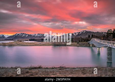 Sunrise view of the Maclaren Foot Bridge in late winter with beautiful snow capped Southern Alps mountain range in the background. New Zealand. Stock Photo