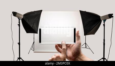 Two hands holding a mobile Smartphone and take a picture of a studio photo Stock Photo