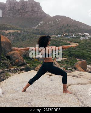 Full length of a slim woman practicing yoga by mountain Stock Photo