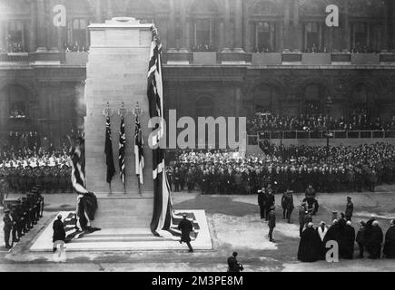 King George V stands facing the Cenotaph during the unveiling ceremony on Armistice Day, 11 November 1920.  Facing him are his three eldest sons, the Prince of Wales, Prince Albert and Prince Henry.  Also present are the Duke of Connaught, the Marquess of Milford Haven (Prince Louis of Battenberg) and Lord Louis Mountbatten.  After the unveiling, the King and the royal party followed the gun carriage bearing the coffin of the Unknown Warrior to Westminster Abbey.     Date: 1920 Stock Photo