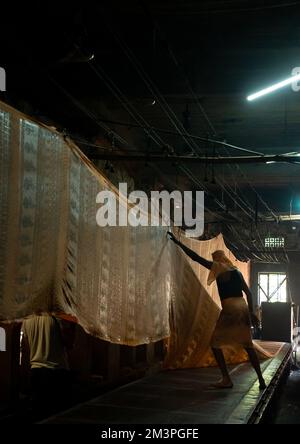 Indian worker drying textiles after manual Screen Printing, Rajasthan, Jaipur, India Stock Photo