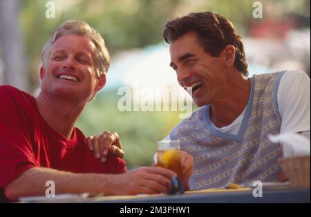 Two middle aged men yuking it up over an iced tea. Stock Photo