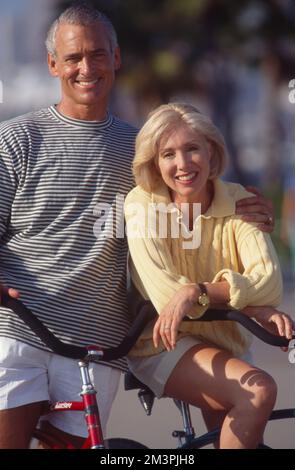 Middle-aged caucasian couple pausing while riding bikes for a portrait Stock Photo