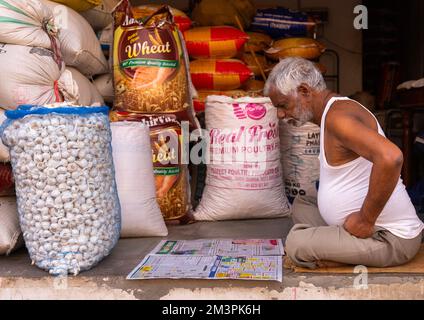 Old indian man reading newspaper in his shop, Rajasthan, Ramgarh Shekhawati, India Stock Photo
