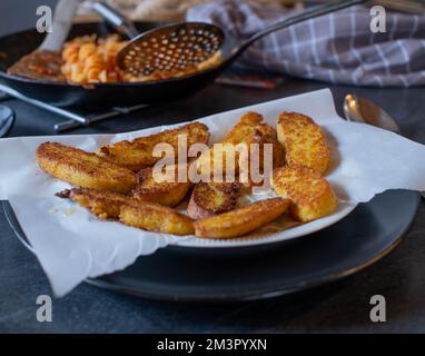 Fried polenta sticks on a plate on kitchen table. Closeup and front view Stock Photo