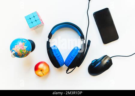 Top view student workspace concept, smartphone, mouse, keyboard, headset on white background with copy space. Kids development. Elementary remote stud Stock Photo