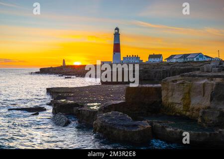 Portland Bill, Dorset, UK.  16th December 2022.  UK Weather.  The sky glows orange at sunset above the lighthouse at Portland Bill in Dorset at the end of a day of clear skies, sunshine and freezing temperatures.  Picture Credit: Graham Hunt/Alamy Live News Stock Photo