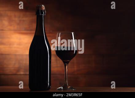 full wine bottle without label with goblet on wooden background Stock Photo