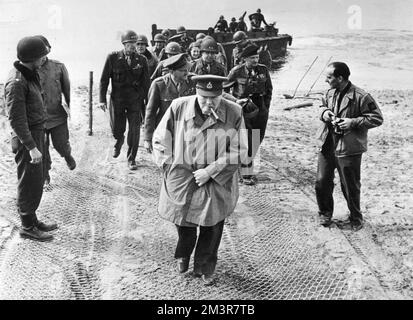 British Prime Minister, Winston Churchill, on the German-held east bank of the Rhine, with Field Marshall Montgomery (in beret) and Field Marshall Brooke (immediately behind Churchill) in March 1945 as part of Operation Plunder in World War Two. They are with US commanders and guards.     Date: 25th March 1945 Stock Photo