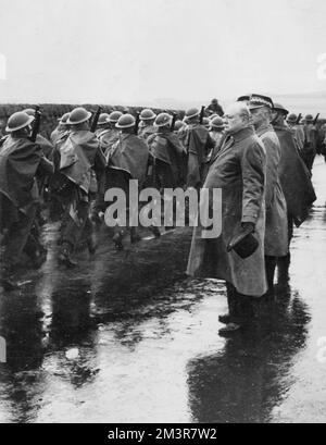 Mr Winston Churchill, hat in hand despite the rain, watches a march-past of troops during his visit to coastal districts of East Scotland, where he inspected more of Britain's defences. With him in the picture can be seen Gernal Sikorski, the Polish Prime Minister. 1940     Date: 1940 Stock Photo