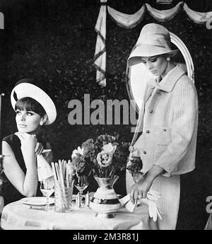 Two girls meet for lunch at the Caprice.  On the left, model wears a slip dress in navy linen by Norman Hartnell's Petit Salon with a navy-edged white panama Breton hat by Jean Barthet.  On the right, a Chanel-styled suit from Paris in turquoise ribbed wool, lined and bloused in turquoise georgette from Fortnum and Mason and a matching felt hat by Otto Lucas.      Date: 1965 Stock Photo