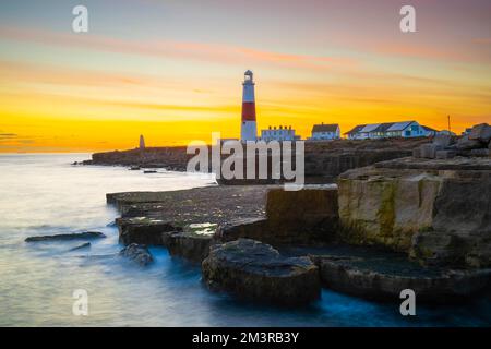 Portland Bill, Dorset, UK.  16th December 2022.  UK Weather.  The sky glows orange at sunset above the lighthouse at Portland Bill in Dorset at the end of a day of clear skies, sunshine and freezing temperatures.  Picture Credit: Graham Hunt/Alamy Live News Stock Photo