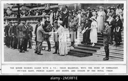 The Queen shaking hands with a V.C.: Their Majesties, with tthe Duke of Connaught, Princess Mary, Princes Albert and Henry, and others of the royal group.     Date: 1920 Stock Photo