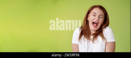 Lazy weekends finally time sleep. Cheerful redhead middle-aged 50s woman yawning satisfied close eyes feel sleepy wake up early morning wanna take nap Stock Photo