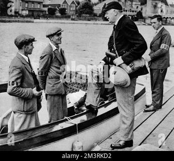 Two members of the Home Guard chat to Colonel Burnell on a pleasure boat, now converted into a Thames patrol boat. Note that the men are wearing 'LDV' armbands. The 'Local Defence Volunteers' were officially renamed the 'Home Guard' on 22 July 1940.  1940 Stock Photo