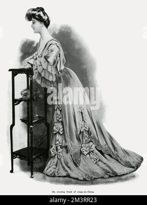 Side-view of a woman wearing an evening frock made from crepe-de-chine, available from Shoolbred, department store.     Date: 1905 Stock Photo