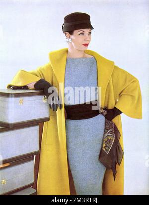 A canary yellow top coat of mohair in a simple wrap shape from Jaegers of Regent Street.       Date: 1954 Stock Photo