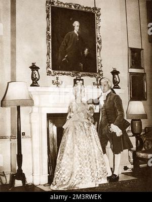 George Child Villiers(1910-1998), 9th Earl of Jersey and his second wife Virginia(1908-1996), the Countess of Jersey. Photographed under the portrait of his ancestor Francis Child at the Georgian Ball, held at Osterley Park in West London. Lord Jersey wore a replica of the costume shown in the painting.     Date: 1939 Stock Photo